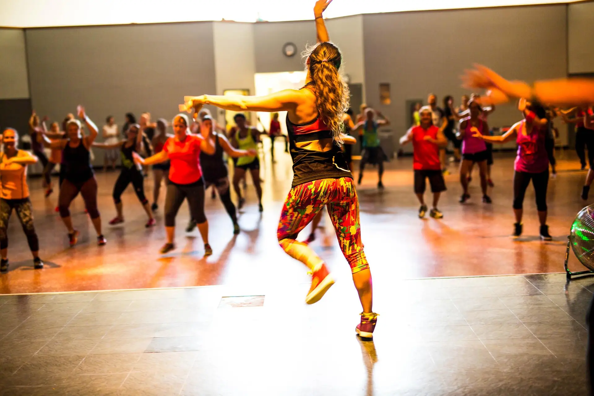 Junge Menschen tanzen gemeinsam bei einer Zumba- oder Dance-Fitness-Stunde.
