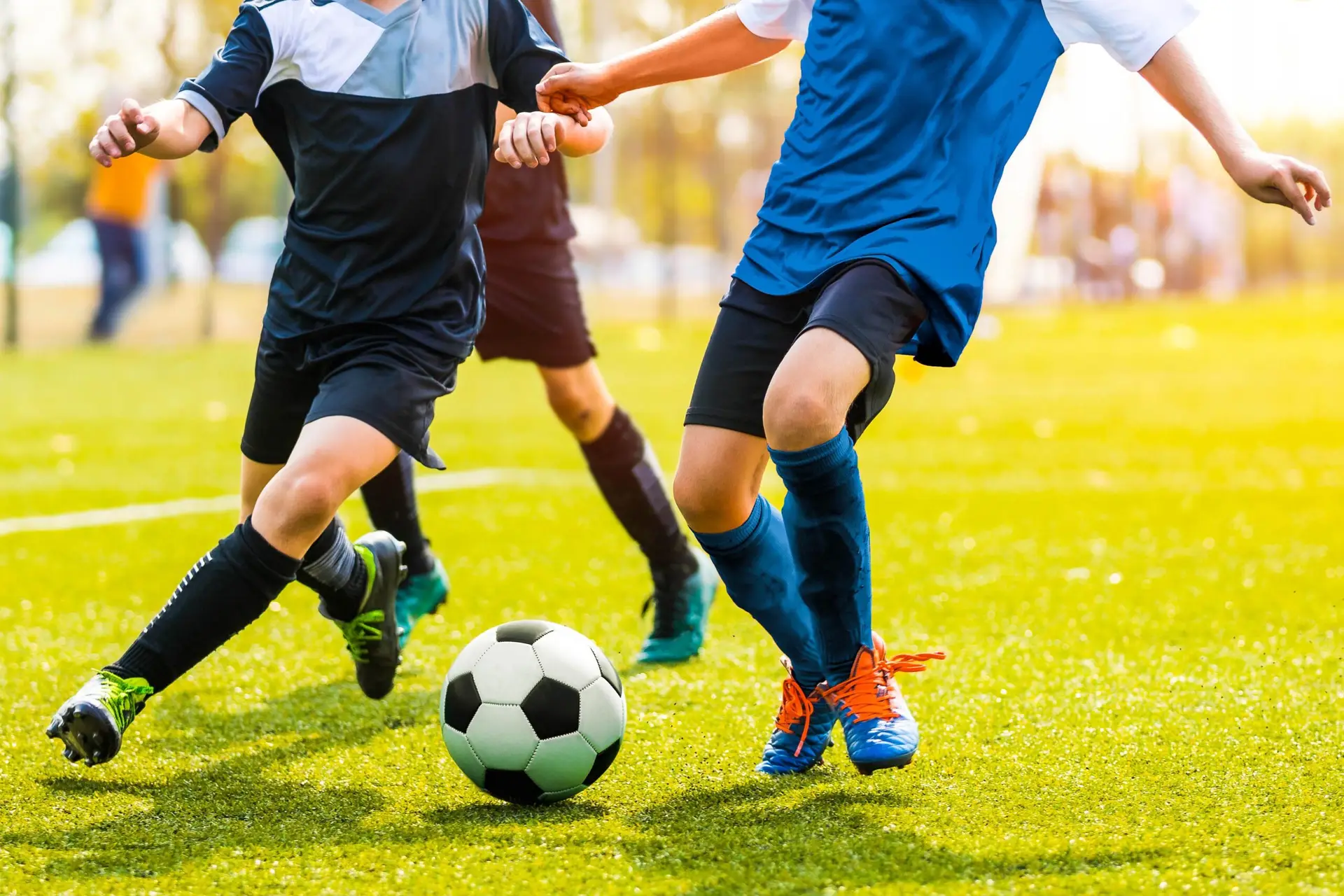 Zwei junge Spieler*innen kämpfen dynamisch um den Ball.
